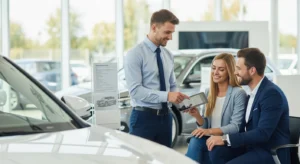 Automobile sales professional consulting with customers in a modern showroom