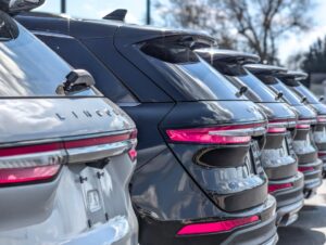 Dealership-sales-training-2026-roi-trends - proactive training solutions Row of shiny lincoln suvs parked in a dealership lot, showing their rear ends and pink taillights. (informative) or similar context-appropriate alt text