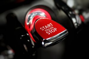 Which-proactive-training-program-is-right-for-your-dealership - proactive training solutions Red engine start/stop button on a car console, indicating the button to start or stop the engine